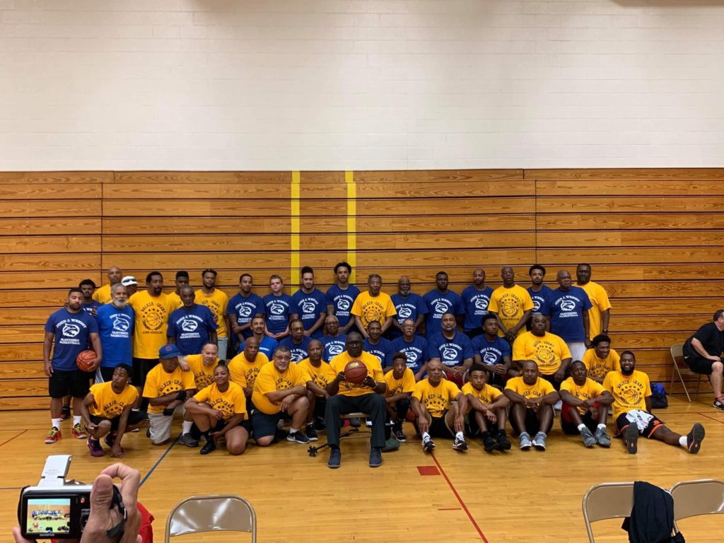 Group of basketball players in gymnasium.